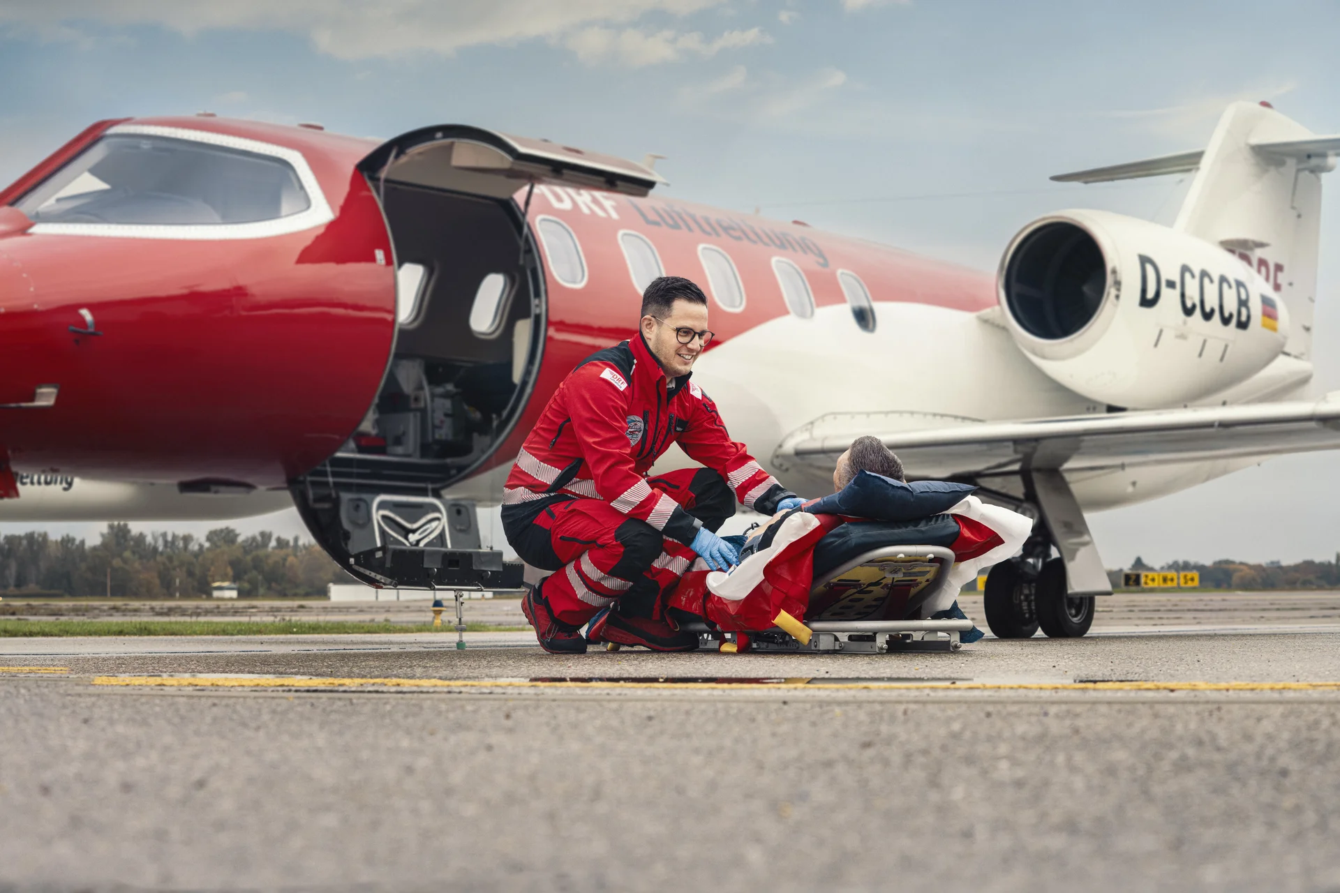 Patiententransport durch die DRF Luftrettung vor einem Ambulanzflugzeug