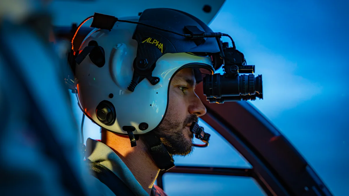 Pilot der DRF Luftrettung mit Nachtsichttechnik im Cockpit