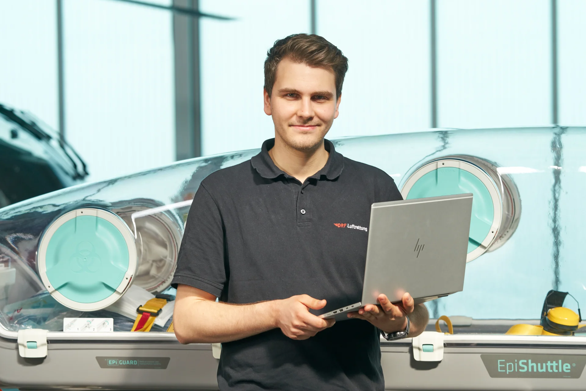 Ein Mann steht mit einem Laptop auf dem Arm vor einem EpiShuttle.