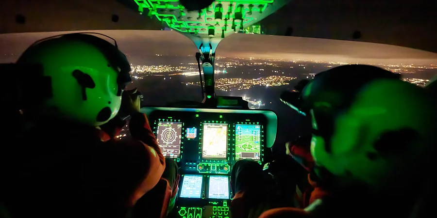 Cockpit eines Rettungshubschraubers beim Einsatz von Nachtsichtbrillen während eines Nachtfluges