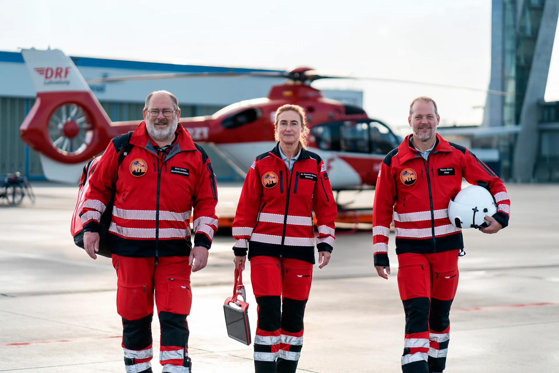 Einsatzcrew der DRF Luftrettung neben dem Rettungshubschrauber Christoph 27 am Flughafen Nürnberg